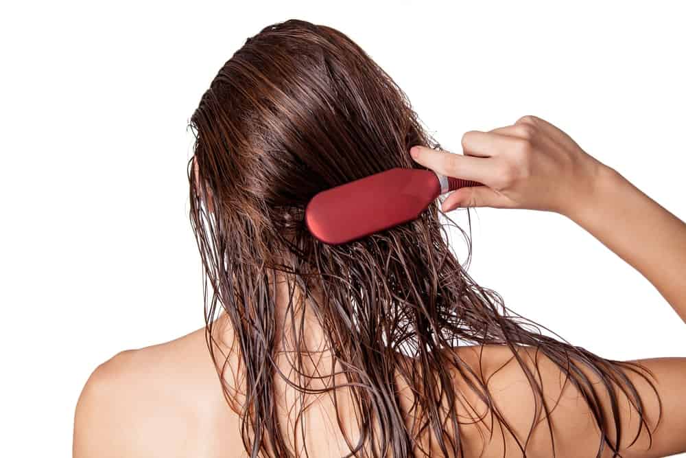A woman brushing her long wet hair.