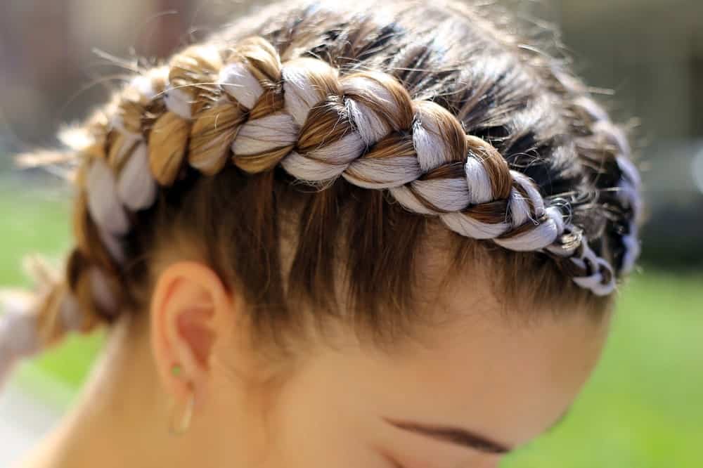 Girl's thick and curly hair braided into a pigtail.