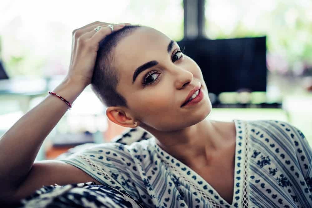 A woman showing off her shaved head.