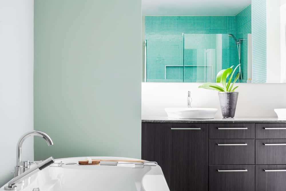 Modern bathroom with white and sage green walls.