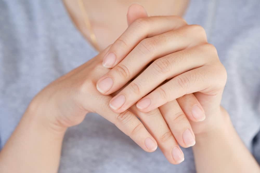 A close look at a woman's hands with a set of healthy nails.